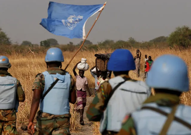 United Nations Mission in South Sudan (UNMISS) peacekeepers meet women and children on their path during a patrol near Bentiu, northern South Sudan, February 11, 2017. (Photo by Siegfried Modola/Reuters)
