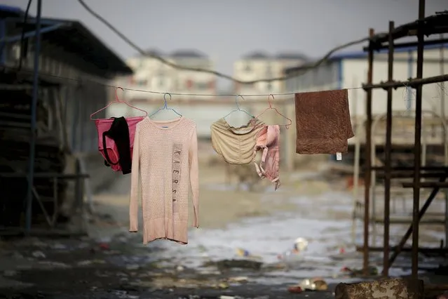 Clothes of migrant workers hang at the construction site of Changxiang Gardens development complex in Fengrun District, Tangshan City, Hebei province, China in this January 28, 2016 file photo. (Photo by Damir Sagolj/Reuters)