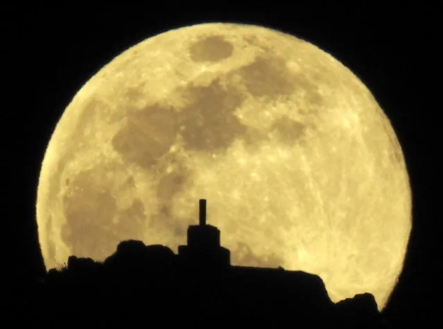 A view of the full moon over Mount Pico Sacro, just outside Santiago de Compostela, Spain, 20 March 2019 (issued 21 March 2019). The third full supermoon of the year, also known as full worm supermoon is the first supermoon in two decades to coincide with the spring equinox. (Photo by Lavandeira Jr./EPA/EFE)