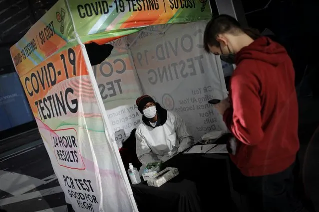A healthcare worker mans a COVID-19 testing tent along 5th avenue amid the spread of the coronavirus disease (COVID-19) in New York City, New York, U.S., December 13, 2021. (Photo by Mike Segar/Reuters)