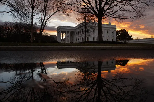 The sun rises behind the White House in Washington, Saturday, December 22, 2018. Hundreds of thousands of federal workers faced a partial government shutdown early Saturday after Democrats refused to meet President Donald Trump's demands for $5 billion to start erecting a border wall with Mexico. Overall, more than 800,000 federal employees would see their jobs disrupted, including more than half who would be forced to continue working without pay. (Photo by Carolyn Kaster/AP Photo)