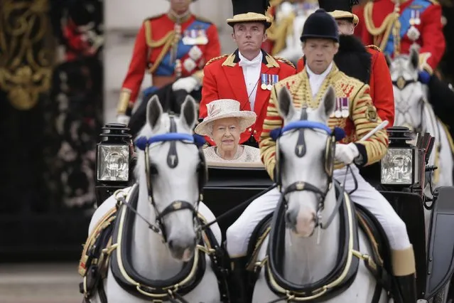 Britain's Queen Elizabeth II rides in a carriage during the Trooping The Colour parade at Buckingham Palace, in London, Saturday, June 13, 2015. Hundreds of soldiers in ceremonial dress have marched in London in the annual Trooping the Color parade to mark the official birthday of Queen Elizabeth II. The Trooping the Color tradition originates from preparations for battle, when flags were carried or "trooped" down the rank for soldiers to see. (AP Photo/Tim Ireland)