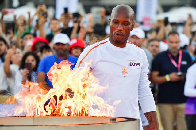 French Ivorian former football player Didier Drogba lights the Olympic and Paralympic Torch Relays cauldron, designed by Mathieu Lehanneur with the Olympic Torch as part of the Olympic and Paralympic Torch Relays at the Stade Velodrome, ahead of the Paris 2024 Olympic and Paralympic Games, in Marseille, southeastern France, on May 9, 2024. The transfer of the flame onshore from a 19th-century tall ship will mark the start of a 12,000-kilometre (7,500-mile) torch relay across mainland France and the country's far-flung overseas territories. (Photo by Sylvain Thomas/AFP Photo)