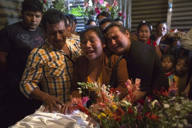 In this Friday, March 10, 2017 photo, Marta Lidia Garcia, center, cries during the wake of her 17-year-old daughter Siona Hernandez, who died in a fire at a children's shelter in which 40 killed perished, in Ciudad Peronia, Guatemala. Relatives and officials said the March 8 blaze began when girls set fire to mattresses to protest abuses at the Virgin of the Assumption Safe House. (Photo by Moises Castillo/AP Photo)