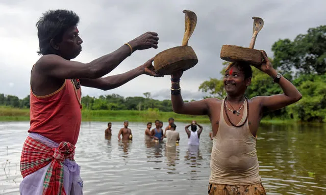 Snake charmers and local villagers perform tricks with venomous snakes at the Jhapan festival in Silli, India on August 18, 2019. Jhapan Festival is the largest Snake Festival of Bengal and Jharkhand where Snakes (cobras, pythons, vipers) are being worshipped as a part of Traditional Ritual. This ritual happen during Manasa Puja, (The Hindu Goddess of Snake & curing Snake bites) which falls generally mid of August every year. (Photo by Avishek Das/SOPA Images/Rex Features/Shutterstock)