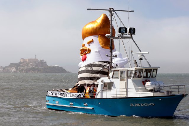 An inflatable “Trump Chicken” balloon, wearing a black-and-white-striped convict top, sails in protest in front of Alcatraz Island (a former maximum security federal penitentiary) during a protest of former President Donald J. Trump’s visit for a fundraiser, in San Francisco, California, USA, 06 June 2024. (Photo by John G. Mabanglo/EPA/EFE)