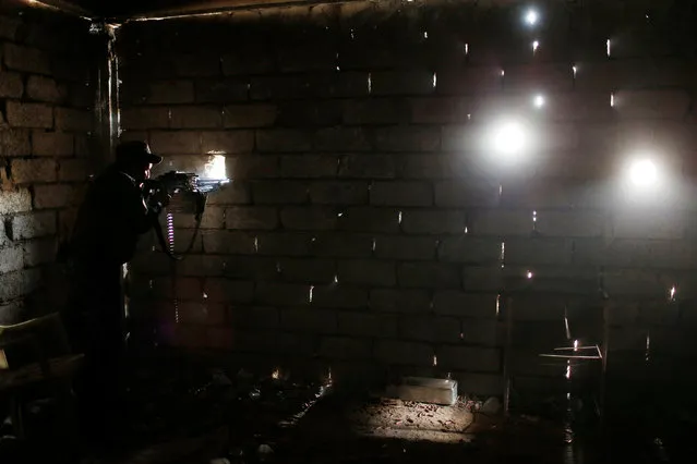 A sniper of the Iraqi Federal Police takes his position at a destroyed builiding near Islamic State fighters' positions at Bab al Jadid district in the old city of Mosul, Iraq, March 27, 2017. (Photo by Youssef Boudlal/Reuters)