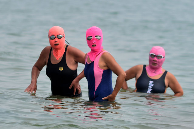 Three people wear face-kinis to cool off in the water at the No. 1 Bathing Beach in Qingdao, East China's Shandong province, June 17, 2024. (Photo credit should read CFOTO/Future Publishing via Getty Images)