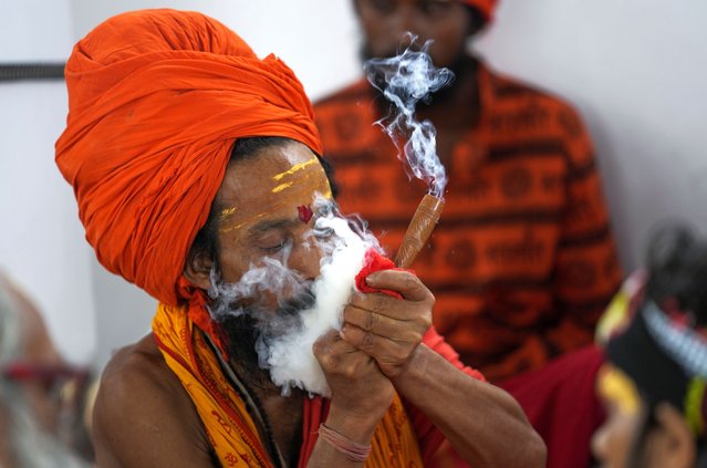 A Hindu holy man smokes as he waits in Jammu, India, to register for the annual pilgrimage to the Amarnath cave shrine, Thursday, June 27, 2024. The pilgrimage held annually to the holy Amarnath cave, dedicated to Hindu god Shiva is scheduled to start on June 29 this year. (Photo by Channi Anand/AP Photo)