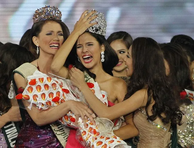 Jamie Herrel (C) of Cebu city, central Philippines, holds onto her crown as she is congratulated by other candidates after being crowned as Miss Philippines-Earth 2014 on coronation night in Manila May 11, 2014. Herrel, competed against 49 other candidates for the top post of Miss Philippines-Earth and will represent the country in the coming 2014 Miss Earth beauty pageant which advocates in preserving the environment, local media reported. (Photo by Romeo Ranoco/Reuters)