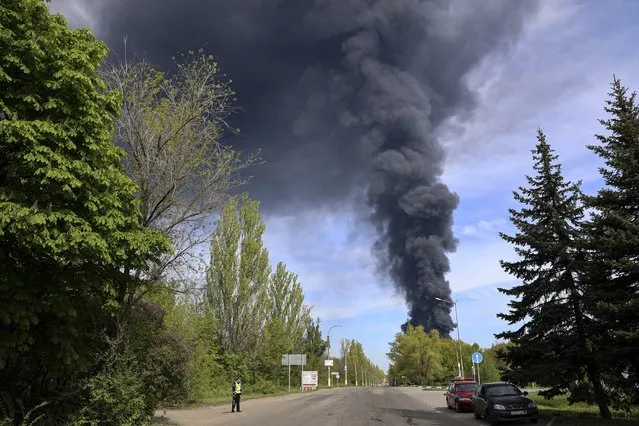 Smoke rises from the oil depot as fire broke out after missiles struck the facility in an area controlled by Russian-backed separatist forces in Makiivka, 15 km (94 miles) east of Donetsk, eastern Ukraine, Wednesday, May 4, 2022. (Photo by Alexei Alexandrov/AP Photo)