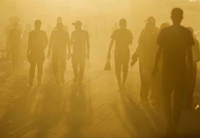 Palestinians walk in an area damaged during the Israeli offensive, amid the ongoing conflict between Israel and Hamas, in Khan Younis, in the southern Gaza Strip on August 20, 2024. (Photo by Mohammed Salem/Reuters)