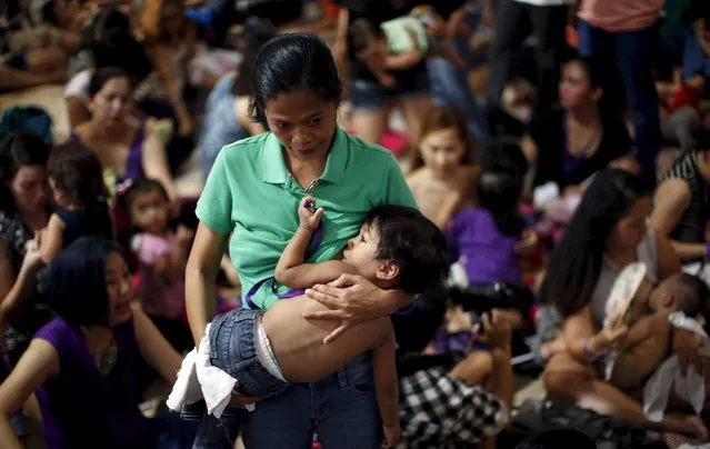 A mother breastfeeds her child in Mandaluyong city, Metro Manila in the Philippines August 1, 2015”. (Photo by Erik De Castro/Reuters)