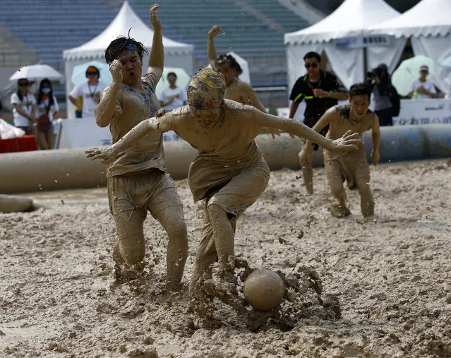 Players battle for the ball during their match at the swamp soccer China tournament in Beijing, June 26, 2014. The 32 teams from across the country participated in the soccer event to celebrate the 2014 World Cup in Brazil. (Photo by Kim Kyung-Hoon/Reuters)