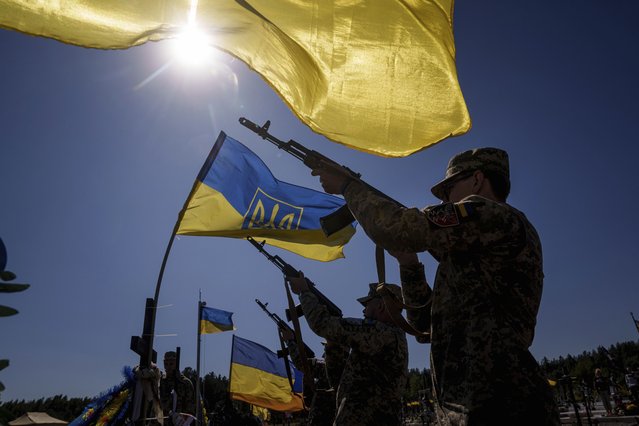 Honor guards shoot into the air during the funeral ceremony of six Ukrainian servicemen killed in a Russian rocket attack at a Ukrainian military academy, during their funeral ceremony in Poltava, Ukraine, Saturday September 7, 2024. (Photo by Evgeniy Maloletka/AP Photo)