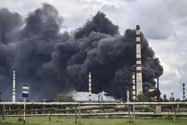 Smoke rises from an oil refinery after an attack outside the city of Lysychans'k in the eastern Ukranian region of Donbas, on May 22, 2022, on the 88th day of the Russian invasion of Ukraine. (Photo by Aris Messinis/AFP Photo)