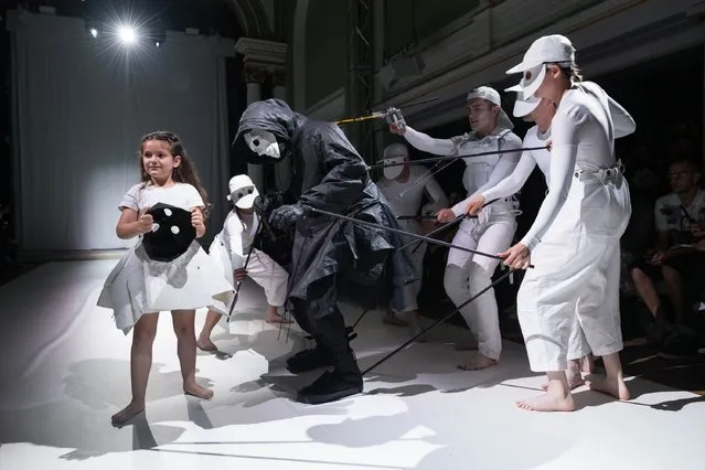 Performers operate a puppet wearing designs by Aitor Throup on the runway during the Aitor Throup show during London Collections Men SS17 at 1 Marylebone on June 12, 2016 in London, England. (Photo by Ian Gavan/Getty Images)