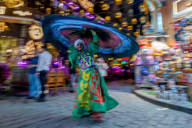 An Egyptian dancer performs the Tanoura outside a coffee shop at al-Muizz street in the old Islamic quarter of Cairo on August 29, 2024. (Photo by Khaled Desouki/AFP Photo)