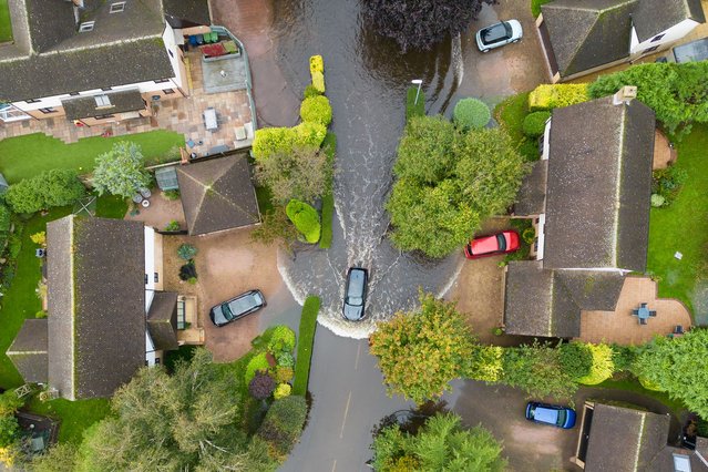 A car makes its way along a flooded road in Brampton, Cambridgeshire, UK on Wednesday, October 2, 2024. Further showery spells are expected across England, but drier, more settled weather conditions are set to arrive in the coming days. (Photo by Joe Giddens/PA Images via Getty Images)