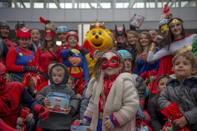 People dressed as comic book superheros pose with children as they distribute gifts at Pristina Children's Hospital during an event organized by the Kosovo Alpin Club and “Care for Kosovo Kids”, a Dutch organization that provides life-saving medicines for children battling cancer in Kosovo, on December 13, 2024. (Photo by Armend Nimani/AFP Photo)