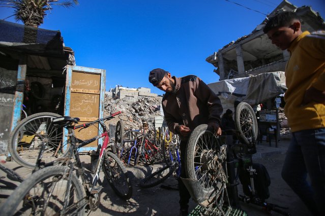 A man repairs bicycles at the Bureij refugee camp in the central Gaza Strip on December 21, 2024, amid the ongoing war between Israel and the Palestinian Hamas movement. (Photo by Eyad Baba/AFP Photo)