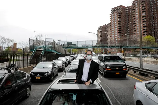 A man looks out of his car during a traffic stoppage, during the outbreak of the coronavirus disease (COVID-19) in New York City, New York, U.S., April 20, 2020. (Photo by Andrew Kelly/Reuters)
