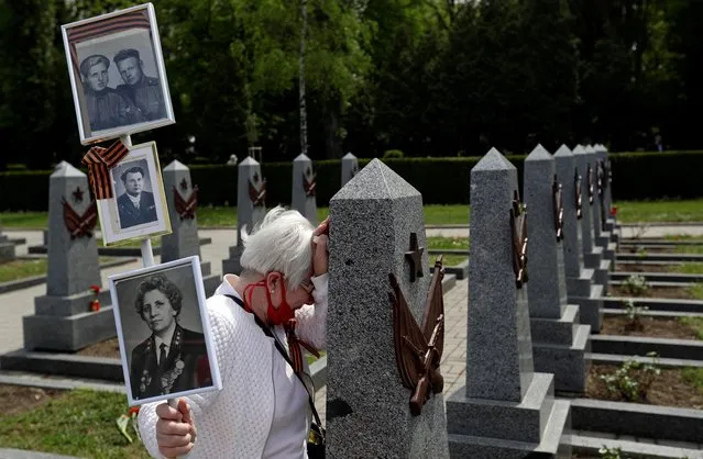 A woman mourns at a grave of a Russian soldier at the Olsany cemetery to commemorate the 75th anniversary of the end of World War Two in Prague, Czech Republic, May 8, 2020. (Photo by David W. Cerny/Reuters)