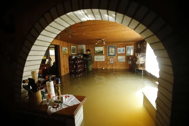 A man looks through his belongings at his flooded home in Zazina village, central Croatia, September 15, 2014. Heavy rain has been falling since Wednesday, causing rivers to rise, closing roads and threatening houses and factories. No deaths or injuries have been reported so far. (Photo by Antonio Bronic/Reuters)