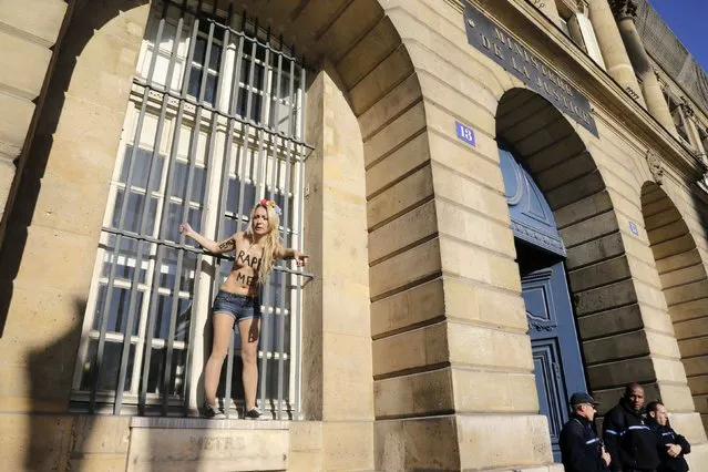 A member from women's rights group Femen, who is topless with messages written on her chest, stages a protest in front of the Justice Ministry at the Place Vendome in Paris October 15, 2012 against the verdict in the gang-rape of teenage girls' trial. After a four-week trial in Fontenay-sous-Bois near Paris, four of the accused were found guilty of taking part in gang-rapes but 10 were acquitted last week. The sentences were far lighter than those recommended by the state prosecutor, who had called for prison sentences of five to seven years for eight of the men. (Photo by Jacky Naegelen/Reuters)
