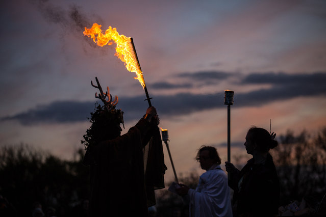 A man representing the Winter King holds a flaming sword as he takes part in a ceremony as they celebrate Samhain at the Glastonbury Dragons Samhain Wild Hunt 2017 in Glastonbury on November 4, 2017 in Somerset, England. (Photo by Matt Cardy/Getty Images)