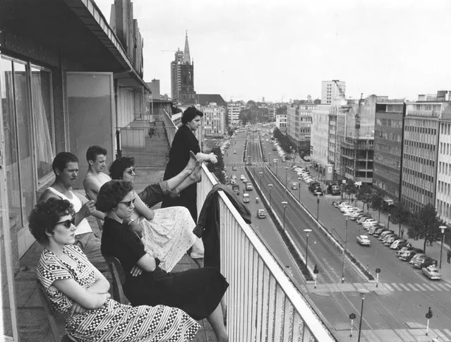 A family relax on their balcony overlooking Berliner Allee in Dusseldorf. 18th July 1957. (Photo by Keystone)
