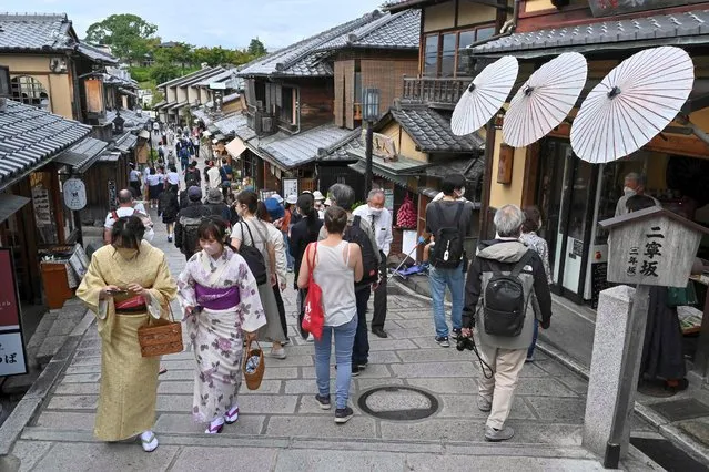 Visitors walk along one of the lanes filled with touristy shops and restaurants leading to Kiyomizu-dera temple in Kyoto on October 13, 2022. (Photo by Richard A. Brooks/AFP Photo)