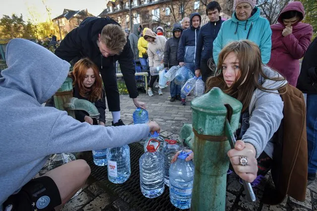 People take water from a water pump in Kyiv, Ukraine, 31 October 2022. “Part of the capital has been left without power as a result of strikes on critical infrastructure facilities. There is no running water in several of the city's districts”, Kyiv mayor Klitschko said. Russian troops on 24 February entered Ukrainian territory, starting a conflict that has provoked destruction and a humanitarian crisis. (Photo by Oleg Petrasyuk/EPA/EFE)