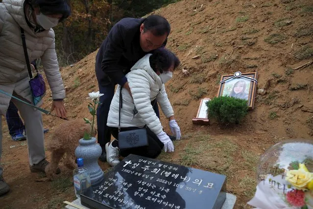 Lee Hyo-sook, 61, mother of Jung Joo-hee, 30, who was one of the victims of a crowd crush that happened during Halloween festivities, grieves nex to her daughter's grave in Namyangju, South Korea on November 3, 2022. (Photo by Kim Hong-Ji/Reuters)