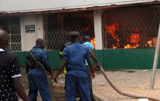Policemen and volunteers attempt to extinguish a fire at the Chinese-owned T2000 supermarket in Burundi's capital Bujumbura, September 21, 2015. Merchandise mainly imported from China of unknown value was charred when a fire alleged to have been caused by an electrical fault gutted the supermarket, Burundian police said. (Photo by Evrard Ngendakumana/Reuters)