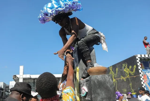 Followers reach out to an “Ougan” or Voodoo priest during the Day of the Dead celebrations at the Cemetery of Port-au-Prince, in Port-au-Prince, Haiti on November 1, 2022. (Photo by Ralph Tedy Erol/Reuters)