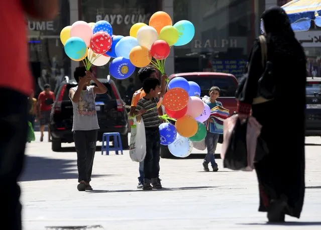 Syrian refugee boys sell balloons ahead of the Eid al-Adha festival in the port-city of Sidon, southern Lebanon September 22, 2015. Muslims across the world are preparing to celebrate the annual festival of Eid al-Adha or the Feast of the Sacrifice, which marks the end of the annual haj pilgrimage, by slaughtering goats, sheep, cows and camels in commemoration of the Prophet Abraham's readiness to sacrifice his son to show obedience to Allah. (Photo by Ali Hashisho/Reuters)