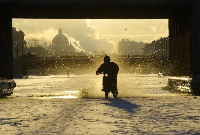 A biker rides on the frozen Fontanka river in central Saint Petersburg, Russia on February 9, 2017. (Photo by Olga Maltseva/AFP Photo)