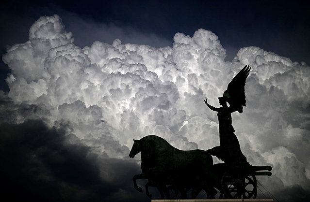 This photograph shows clouds over a statue of the national monument to Italy's King Vittorio Emanuele II, also known as Vittoriano, in Rome on March 26, 2025. (Photo by Filippo Monteforte/AFP Photo)