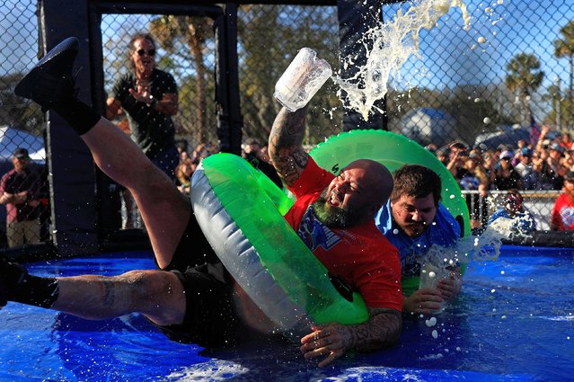 Jon Davis, left, loses his footing and most of his beer against Gary “Doughboy” Anderson, both of Jacksonville, in the “Florida Sumo” competition during the inaugural Florida Man Games, Saturday, February 24, 2024, at Francis Field in St. Augustine, Fla. Hundreds turned out to witness the Floridian Olympic-style events. Team “Hanky Spanky”, based out of St. Augustine, would take home the championship belt. (Photo by Corey Perrine/AP Photo)