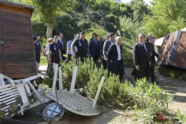 French President Francois Hollande (R) walks near debris during his visit to the Camping du Pylone site to observe damage after flooding caused by torrential rain in Biot, France, October 4, 2015. Flooding along part of the French Riviera has killed at least 16 people, officials said Sunday. The downpour hit the Alpes-Maritimes region, which lies at the eastern end of France's Mediterranean coast and borders Italy, on Saturday evening. (Photo by Jean-Pierre Amet/Reuters)