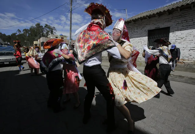 Couples representing the more affluent line dance during the traditional New Year's festival known as “La Diablada”, in Pillaro, Ecuador, Friday, January 5, 2018. Thousands of singing and dancing devils take over the mountain town for six days of revelry in the streets. Local legend holds that anyone who adopts a costume for the celebration and wears it at the event six years in a row will have good luck. (Photo by Dolores Ochoa/AP Photo)