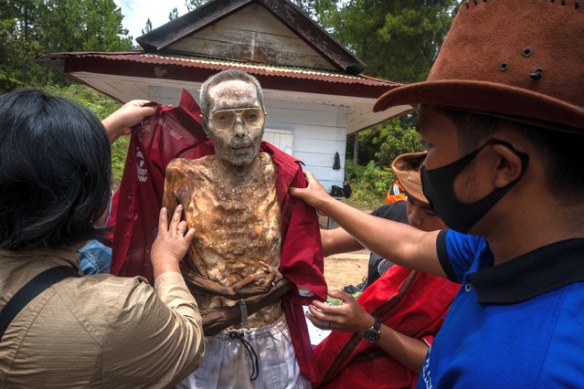Family members put on a new set of clothing on the preserved body of their relative during a traditional ritual called “Manene” in Panggala, Nort Toraja, South Sulawesi, Indonesia, Tuesday, August 25th 2020. (Photo by Hariandi Hafid/ZUMA Wire/Rex Features/Shutterstock)