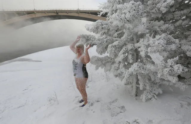Lyubov Valiyeva, member of the Cryophile winter swimmers club, sprinkles herself with snow from branches of a pine on a bank of the Yenisei Riverr, with the air temperature at about minus 38 degrees Celsius (minus 36.4 degrees Fahrenheit), in Krasnoyarsk, Russia January 21, 2018 on January 19, 2018. (Photo by Ilya Naymushin/Reuters)