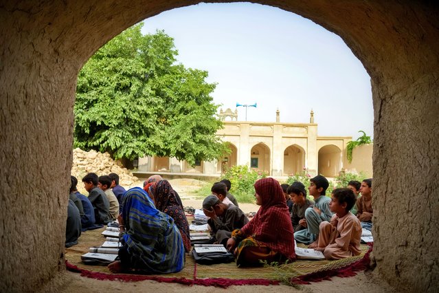Afghan children attend a class at an open air school in the Zhari district of Kandahar province on May 26, 2025. (Photo by Sanaullah Seiam/AFP Photo)