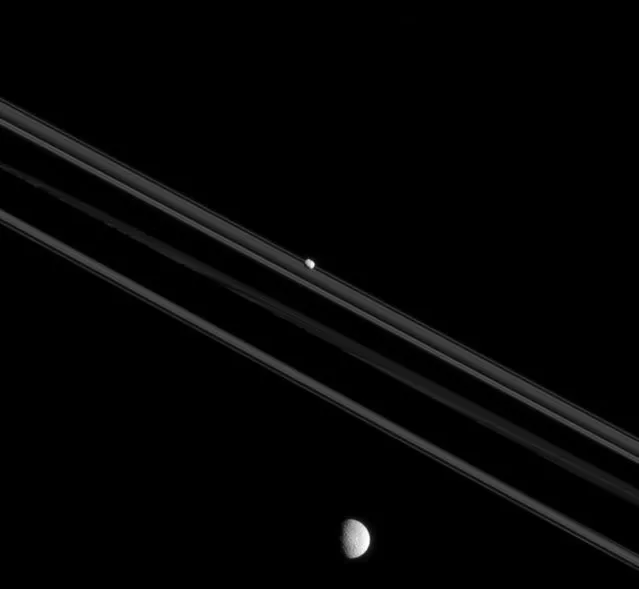 A handout picture made available by NASA on 14 October 2015 and taken in visible light with the Cassini spacecraft narrow-angle camera of Saturn's moons Mimas (bottom) and Pandora (top), 26 July 2015. This view looks toward the unilluminated side of Saturn's rings from 0.26 degrees below the ring plane. Pandora (81 km across) is elongated and irregular in shape, while Mimas (396km across) formed into a sphere due to self-gravity imposed by its higher mass. (Photo by EPA/NASA/Space Science Institute)