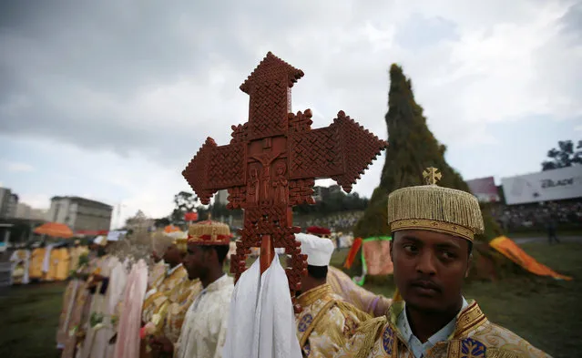 A religious leader carries a cross during the Meskel Festival to commemorate the discovery of the true cross on which Jesus Christ was crucified on, at the Meskel Square in Ethiopia's capital Addis Ababa, September 26, 2016. (Photo by Tiksa Negeri/Reuters)