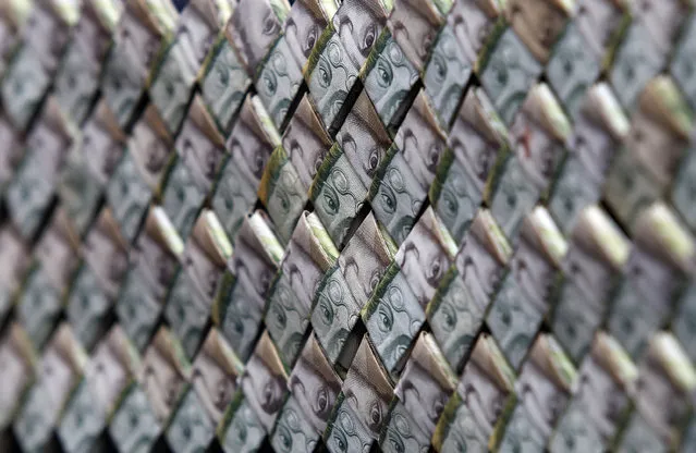 In this February 22, 2018 photo, Venezuelan Bolivars weaved together create a purse that is for sale in La Parada, Colombia, on the border with Venezuela. A family of Venezuelan immigrants to Colombia are repurposing their worthless bolivars into origami-made paper wallets, belts and even purses as the currency plunges further in value amid four-digit inflation. (Photo by Fernando Vergara/AP Photo)