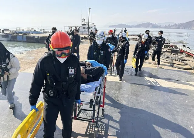 Rescued crew members are carried on stretchers by rescue team as they arrived at a port in Mokpo, South Korea, Sunday, February 5, 2023. South Korean coast guard vessels and aircraft were searching on Sunday in waters off the country's southwestern coast for nine fishermen who disappeared after their boat capsized. (Photo by Jung Hee-sung/Yonhap via AP Photo)