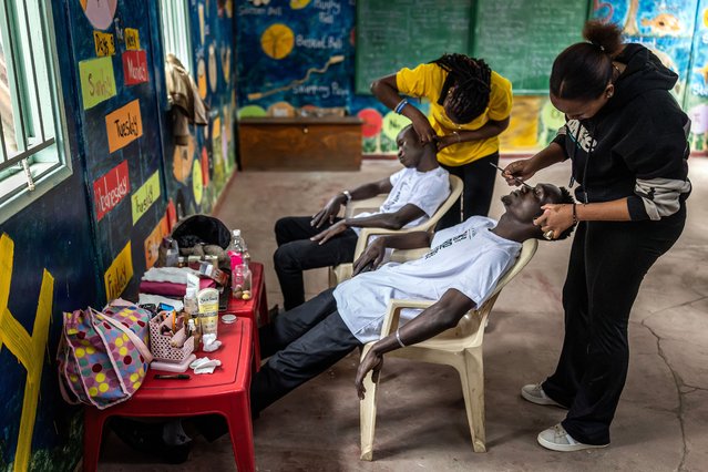 Participants in Mr. & Ms. Kibera 2025, held to mark International Youth Day, have their makeup done in a classroom serving as the backstage area on church grounds in the Kibera informal settlement of Nairobi, on August 12, 2025. Mr. & Ms. Kibera annual pageant champions “bold voices, brilliant minds, and inspiring stories” emerging from Kibera, aiming to showcase youth leadership, resilience, and creativity in East Africa's largest urban informal settlement, while providing a platform for young people to reshape the image of Kibera, and convey socially and politically conscious messages about their community's future. (Photo by Luis Tato/AFP Photo)